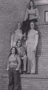 Five women posing on brick steps, vintage.